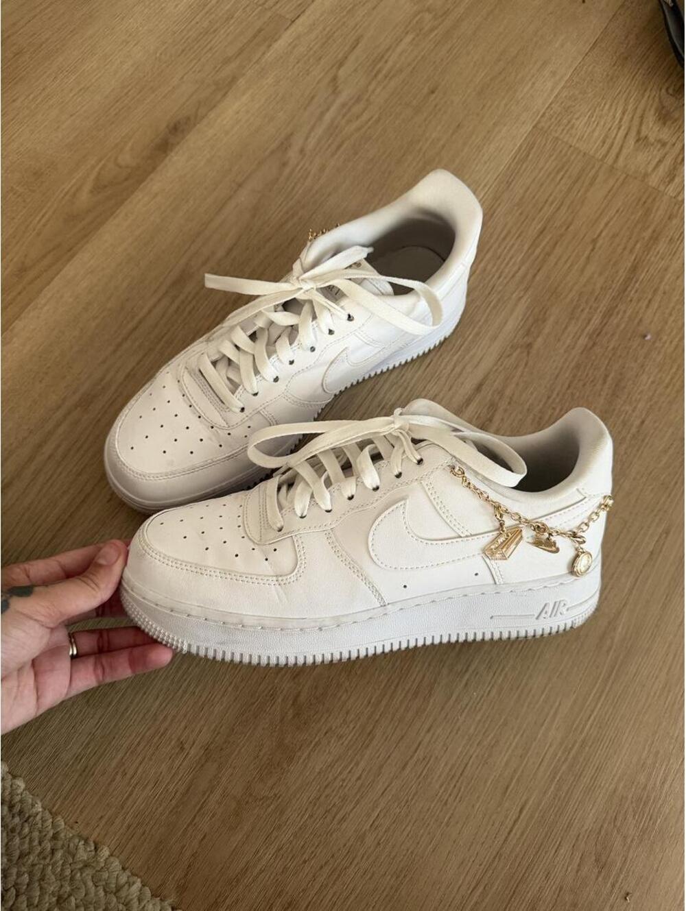 Nike Air Force 1 white sneakers with gold accents